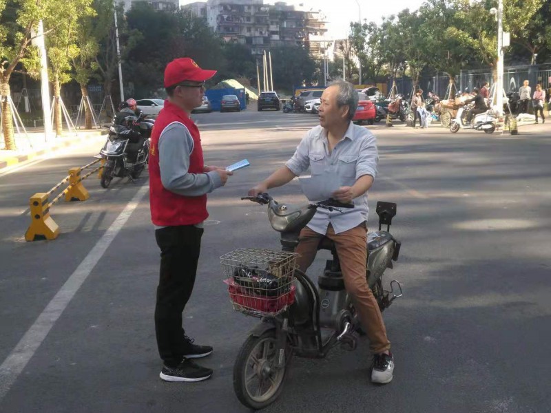 工委党员志愿者向路人宣传安全骑行